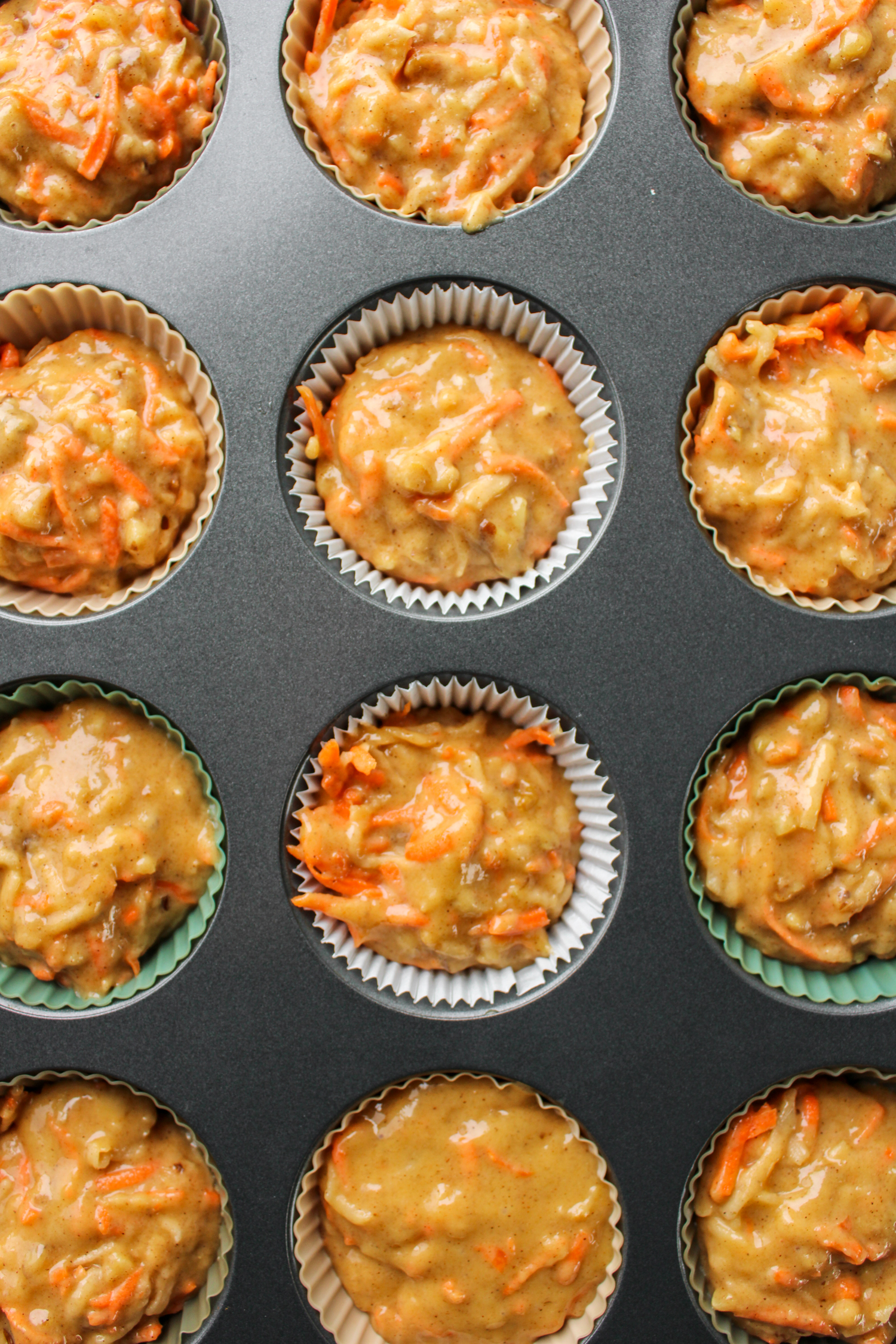 overhead shot of raw carrot apple muffin batter in the baking pan