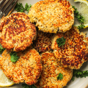 salmon sweet potato cakes on a grey ceramic plate topped with fresh parsley
