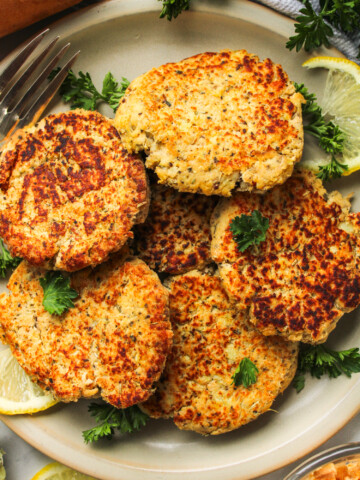 salmon sweet potato cakes on a grey ceramic plate topped with fresh parsley