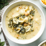 overhead shot of vegetarian egg drop soup in a white ceramic bowl on a white marble background