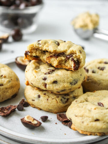 hazelnut chocolate chip cookies stacked on top of each other with cookies surrounding them