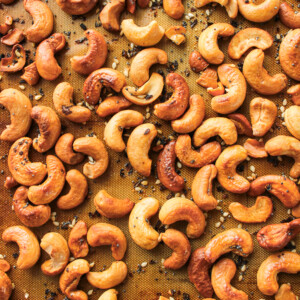 roasted everything bagel cashews on a silicone baking mat on top of a baking sheet