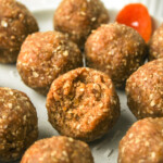 apricot and coconut balls with a bite out of the one in the middle