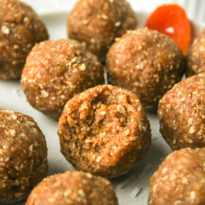 apricot and coconut balls with a bite out of the one in the middle