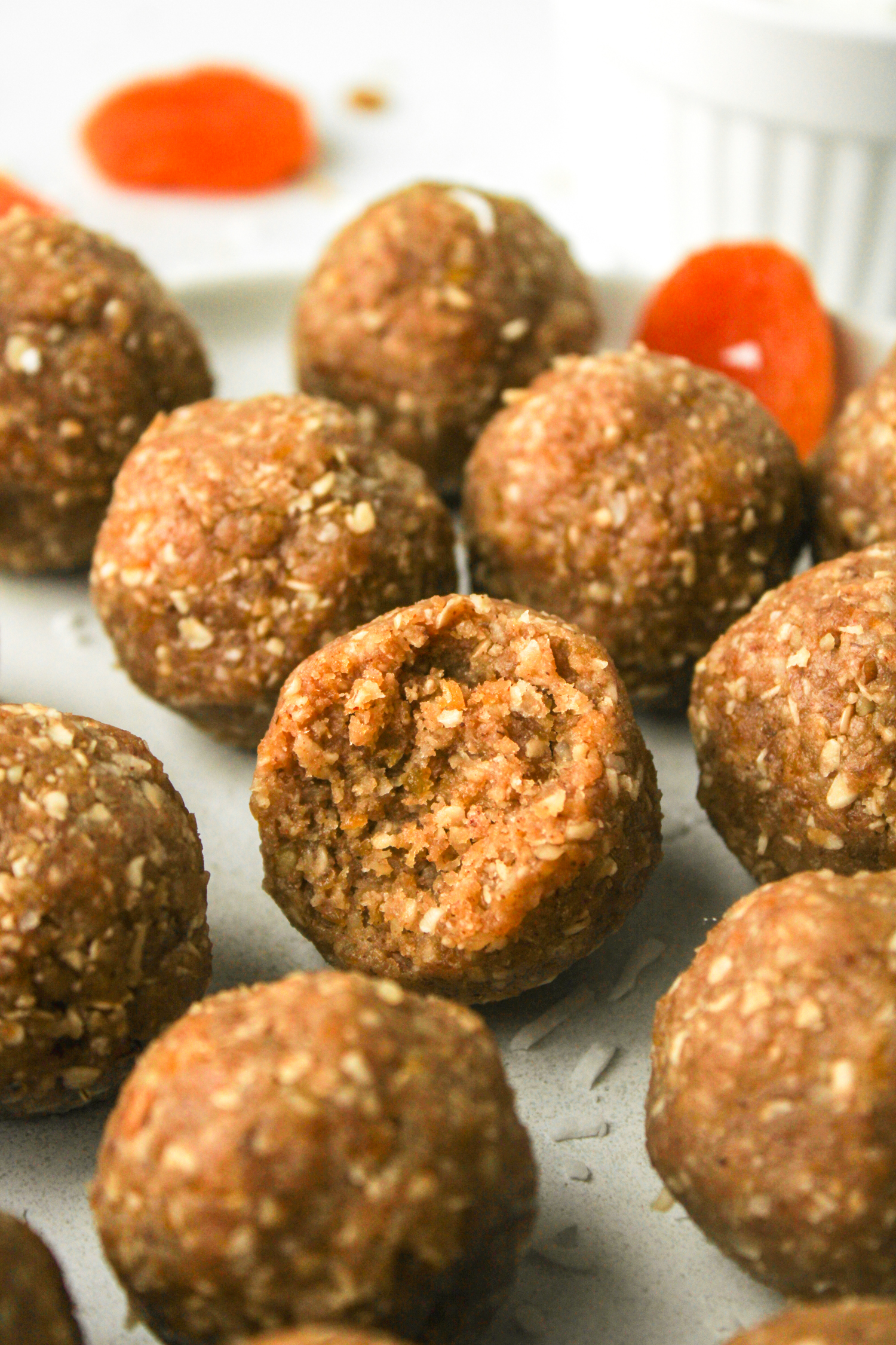 apricot and coconut balls with a bite out of the one in the middle
