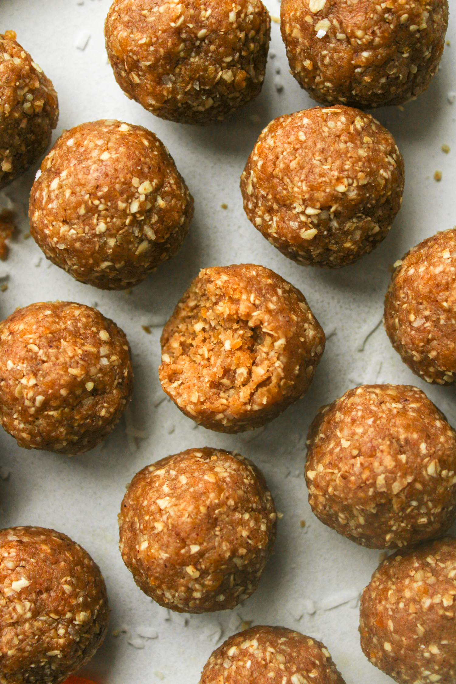overhead shot of apricot and coconut balls with a bite out of the one in the middle