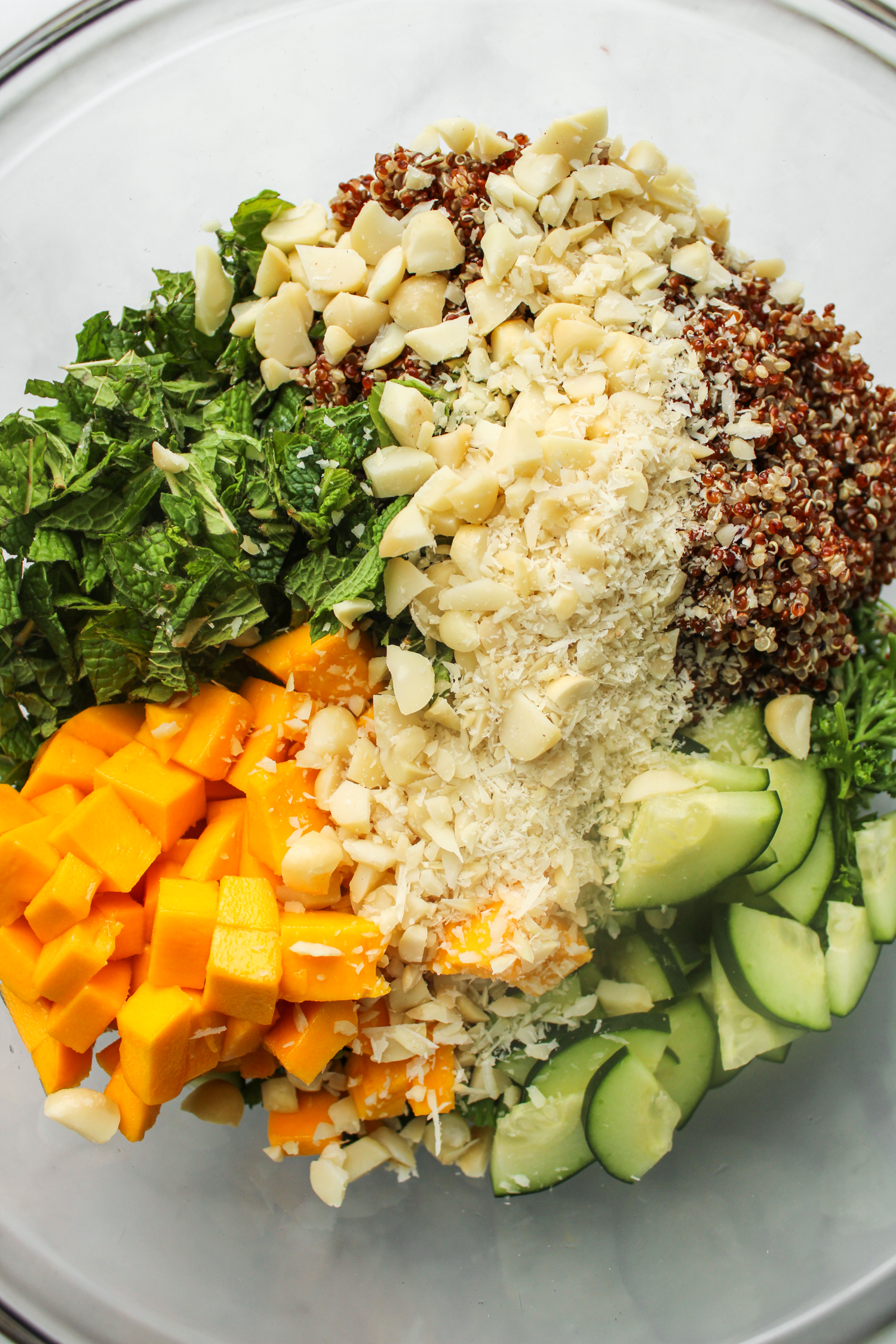 ingredients for the parsley quinoa salad added to a large glass bowl prior to mixing them together