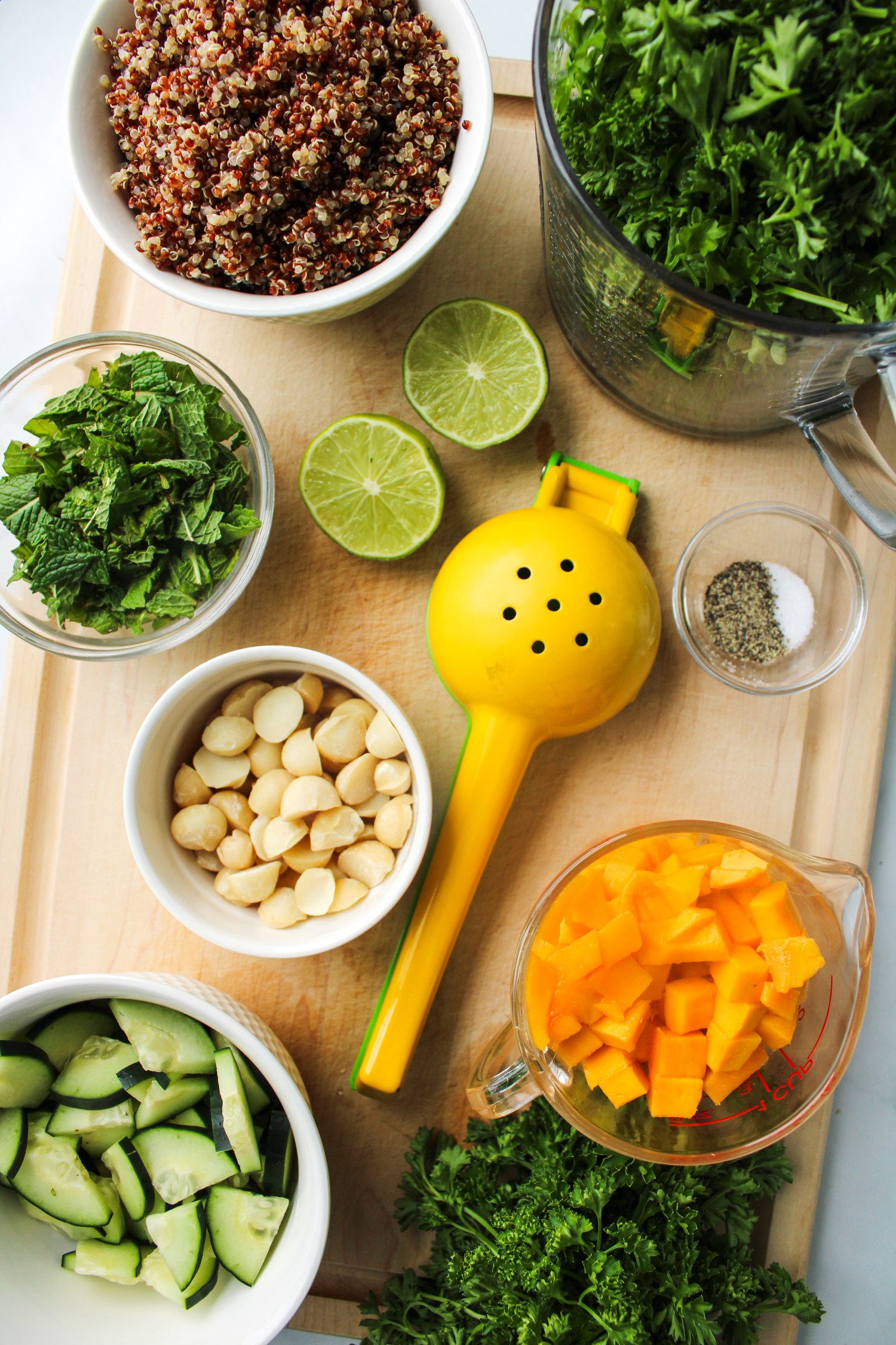 ingredients for the parsley quinoa salad laid out on top of a wooden cutting board