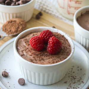 cottage cheese chocolate mousse in a white ceramic dish, topped with chocolate shavings and raspberries