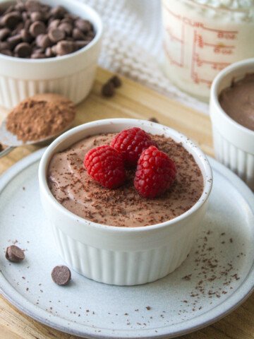 cottage cheese chocolate mousse in a white ceramic dish, topped with chocolate shavings and raspberries