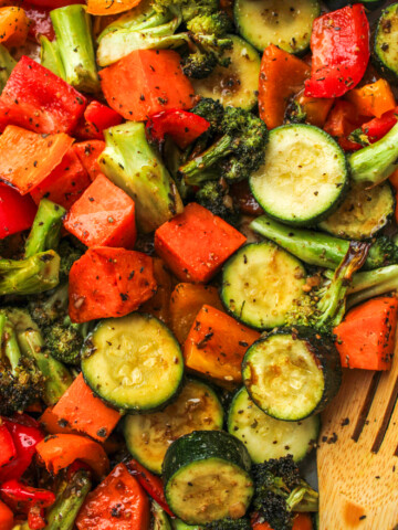 air fryer roasted vegetables with maple balsamic dressing and a wooden spoon to scoop them up