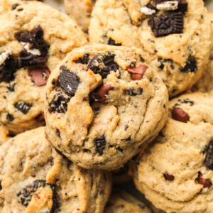 zoomed in oreo and chocolate chips cookies piled on top of each other on a ceramic plate