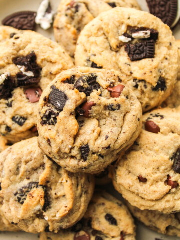 zoomed in oreo and chocolate chips cookies piled on top of each other on a ceramic plate