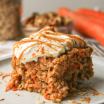 a slice of carrot cake baked oats on a grey ceramic plate topped with Greek yogurt and a drizzle of peanut butter