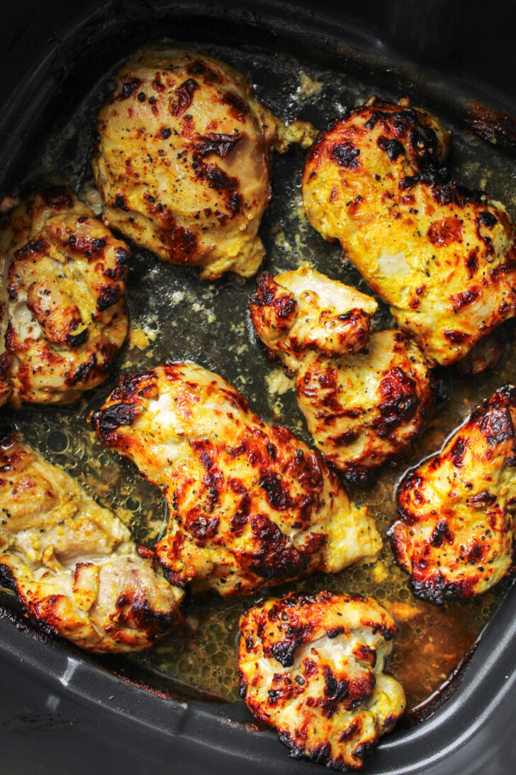 cooked curry chicken thighs in air fryer basket
