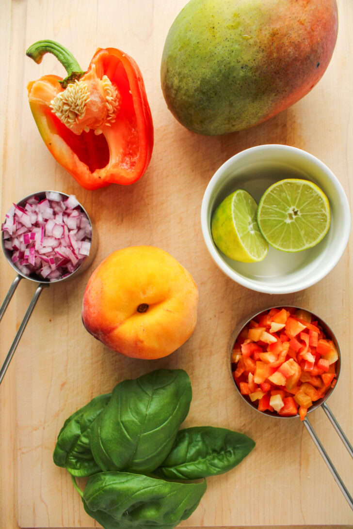 overhead shot of salsa ingredients on a wooden cutting board