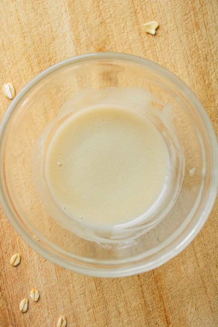vanilla glaze in a small glass bowl on a wooden cutting board