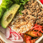 high protein kimchi rice bowls in a white ceramic bowl on top of a wooden cutting board
